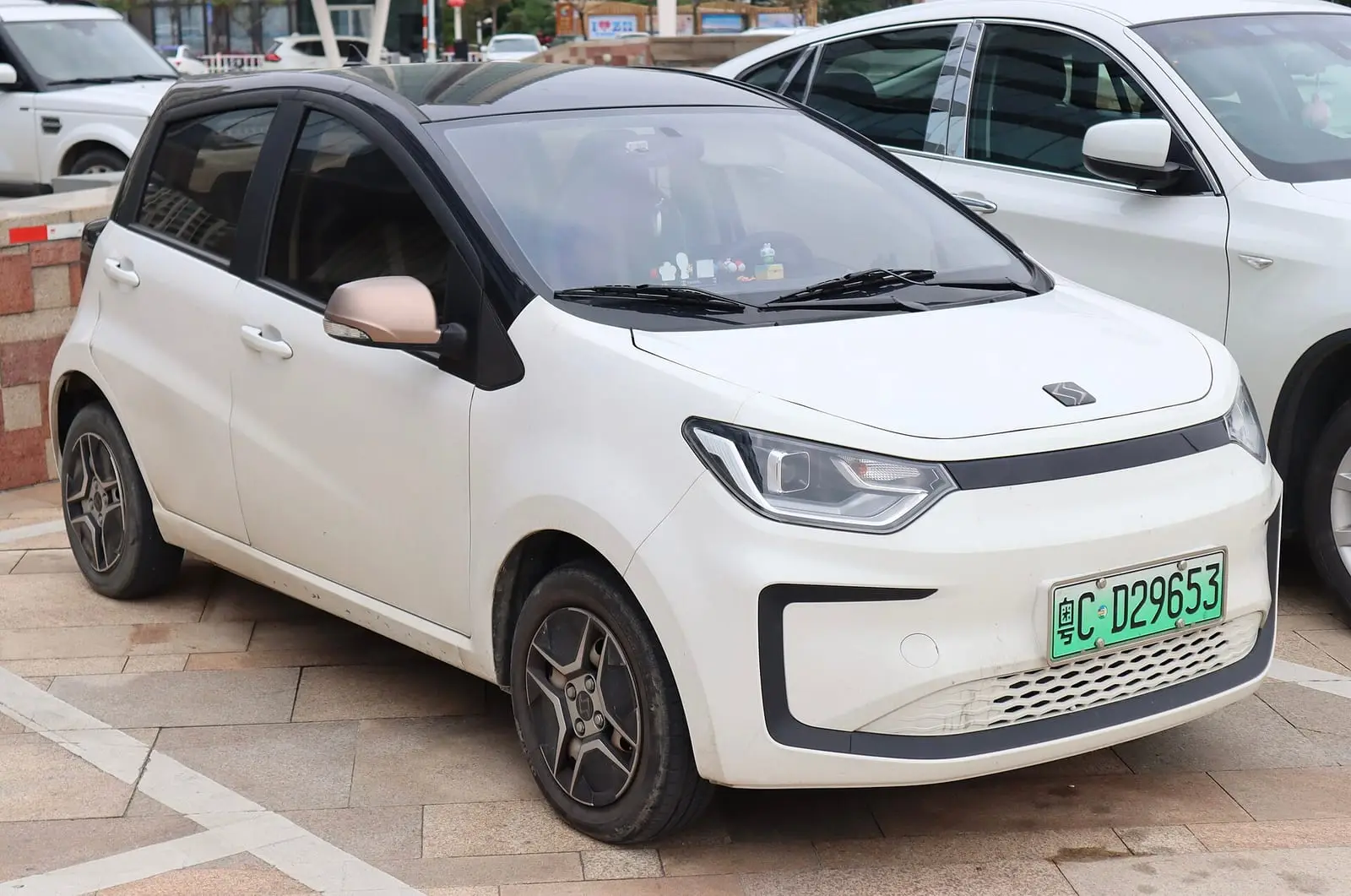 Auto compacto JAC Sehol E10X blanco, visto de frente y de lado