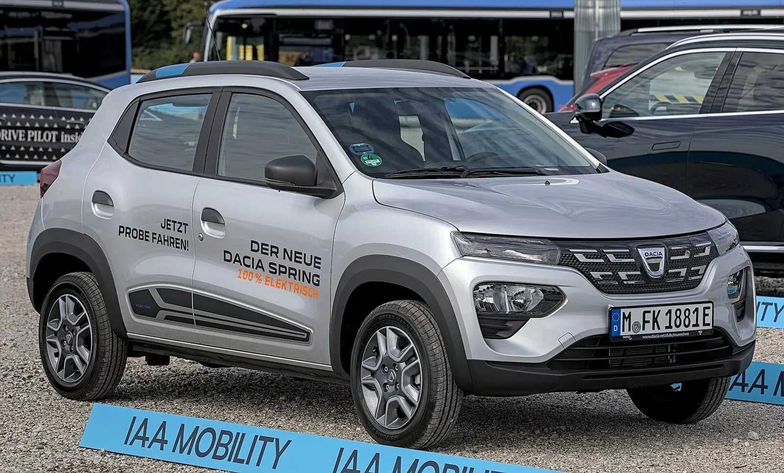 Dacia Spring plateado en una exhibición, visto de frente y de lado